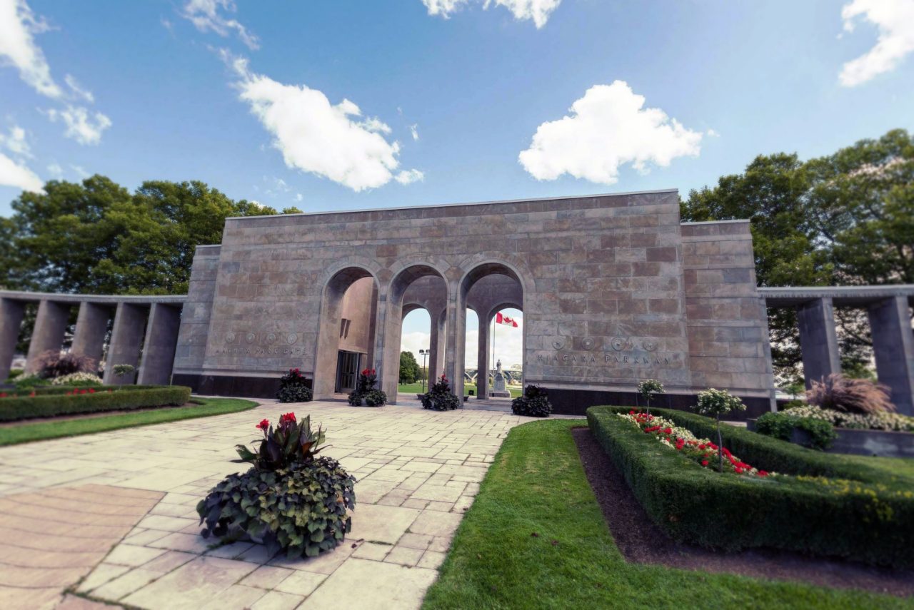 Mather Arch Park & Canadian War Memorial, landscaped gardens and blue sky.